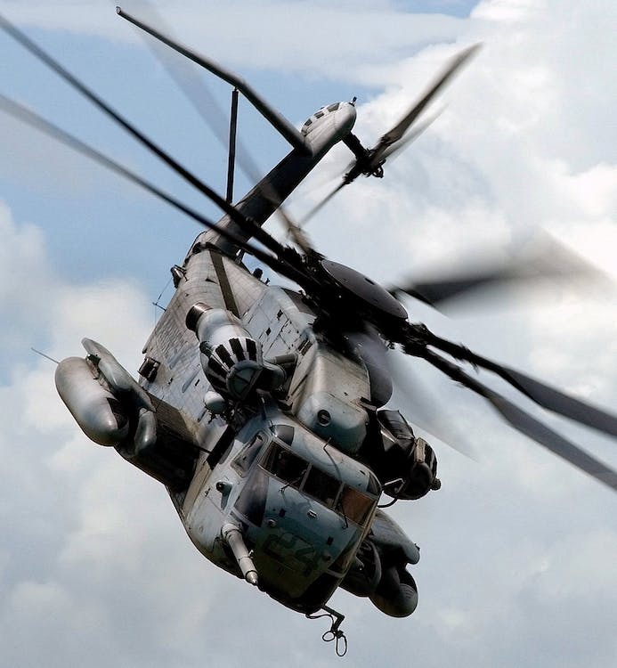 A military helicopter soaring through the sky, equipped with fire safety gear.