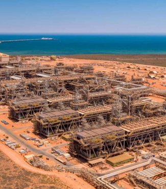 An oil refinery in the desert with the ocean in the background, showcasing fire safety equipment.