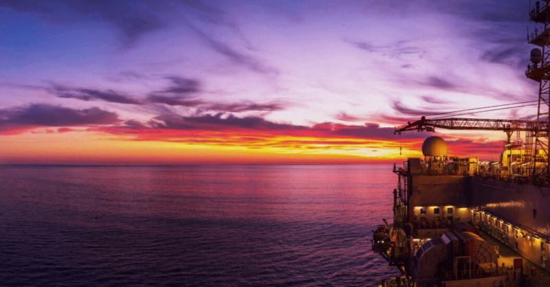 A large oil rig at sunset, with fire safety equipment in place to ensure the safety of the workers and the rig.