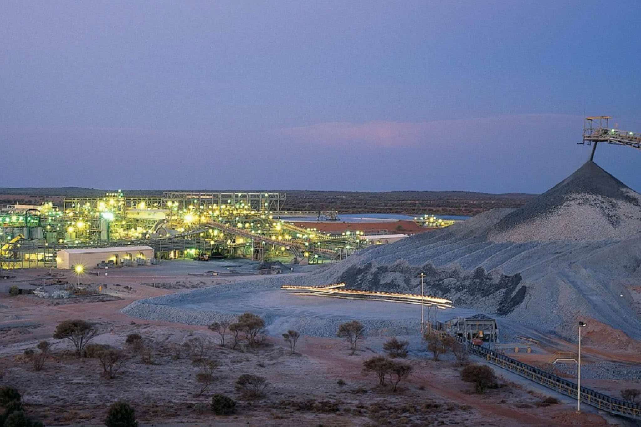 A large pile of sand and gravel in the desert, with fire safety equipment nearby.