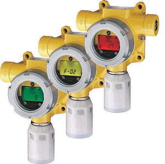 A trio of yellow and green Sensepoint XCD pressure sensors displayed side by side, highlighting their robust construction and features.